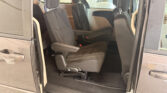 Interior of a dark gray minivan with two front captain's chairs and a middle-row seat; sliding door is open to reveal the cabin symmetry.