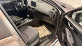 Open driver’s-side view of a dark car interior showing the steering wheel, center touchscreen, and gear shifter.