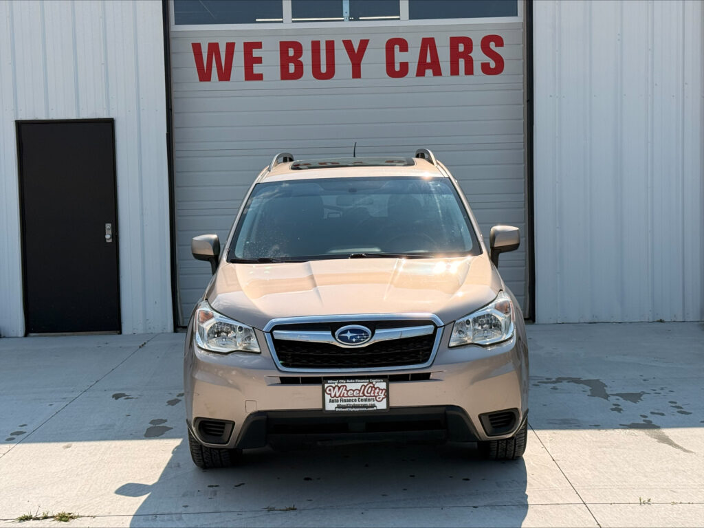 Beige SUV parked in front of a building with a large red 'WE BUY CARS' sign above.