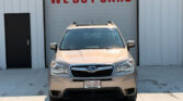 Beige SUV parked in front of a building with a large red 'WE BUY CARS' sign above.
