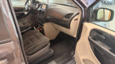 Interior of a vehicle showing the front passenger area with steering wheel, center touchscreen, and beige/black dash panel