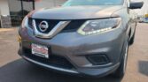 Front view of a gray Nissan SUV parked outside Wheel City Auto dealership with a red sign overhead reading 'Wheel City Auto'