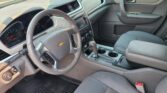 Interior view of a car cabin showing the steering wheel, dashboard with infotainment screen, center console, and front seats.