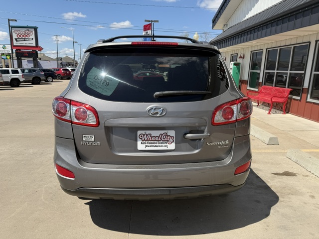 Rear view of a gray Hyundai Santa Fe SUV at a dealership, with a Wheel City license plate frame visible on the bumper.