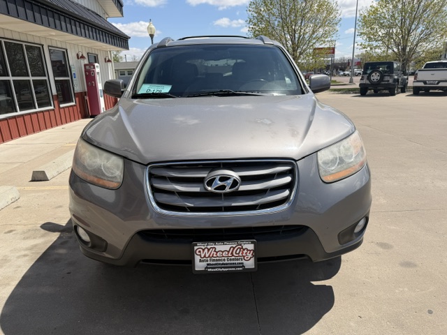 Front view of a gray Hyundai SUV parked in a dealership lot on a sunny day, with a Wheel City license plate frame visible on the front bumper.