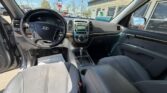 Interior view from the driver's seat of a Hyundai SUV, with the door open, showing the steering wheel, center console, gear selector, and front seats.