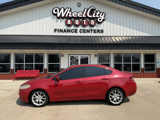 Red sedan parked in front of the Wheel City Auto Finance Centers storefront.