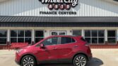 Red compact SUV parked in front of Wheel City Auto Finance Centers storefront, with the dealership sign visible.