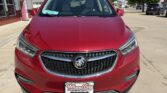 Front view of a red Buick SUV on a dealership lot, chrome grille with Buick emblem visible.