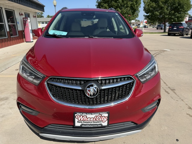 Front view of a red Buick SUV on a dealership lot, chrome grille with Buick emblem visible.