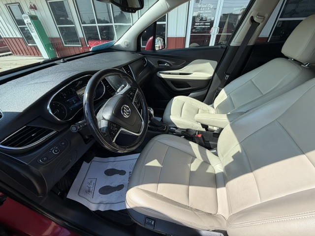 Beige leather front seats and steering wheel visible in a modern car interior.