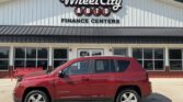 Red SUV parked in front of Wheel City Auto Finance Centers storefront, with the dealership sign visible on a white building.