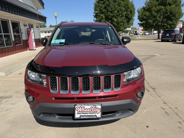 Front view of a red SUV with a black hood guard parked at a car dealership; Wheel City Auto Finance Centers plate frame visible.