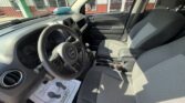 Interior of a Jeep SUV from the driver's side, featuring gray fabric seats, steering wheel, dashboard, center console, and gear shifter