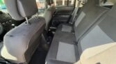 Interior of a car: two front seats and a three-seat rear bench in dark gray fabric, with headrests.