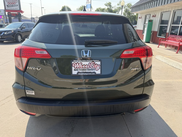 Rear view of a dark gray Honda HR-V AWD parked in a dealership lot, showing the Honda emblem, taillights, and a Wheel City Auto Finance Centers plate frame on the bumper.