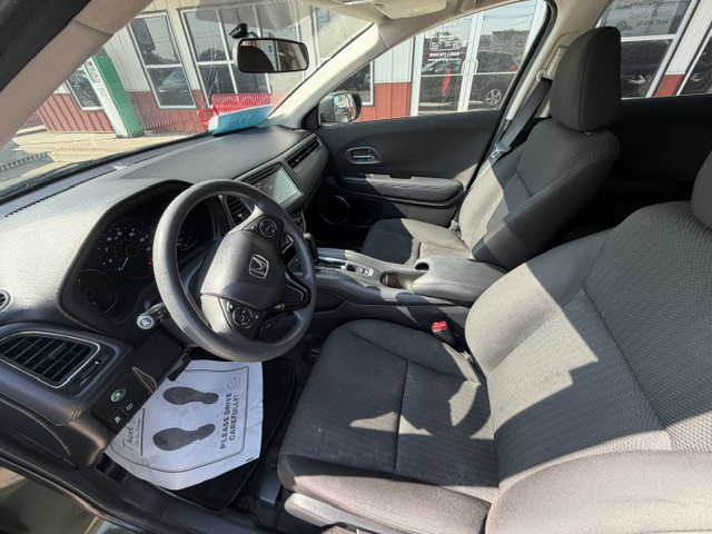 Interior of a Honda sedan’s front cabin with steering wheel, dashboard, and center console visible from the driver’s sideillustration of a clean gray fabric interior.