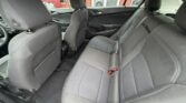 Interior of a car showing the back seats in dark fabric with headrests and seat belts visible