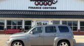 Silver SUV parked in front of Wheel City Auto Finance Centers storefront, with the building's sign visible above.