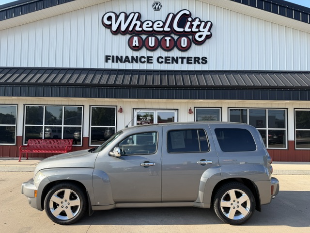 Silver SUV parked in front of Wheel City Auto Finance Centers storefront, with the building's sign visible above.