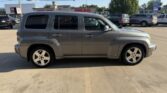 Side view of a silver boxy SUV parked in a dealership lot with other vehicles nearby.