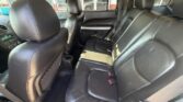 Dark interior of a car showing black leather back seats and front seats, with center console and door panels visible.