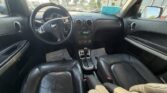 Front interior of a black leather car, showing the steering wheel, center console, and front seats.
