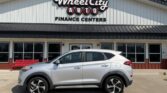 Silver SUV parked in front of Wheel City Auto Finance Centers storefront, sign visible above the building.