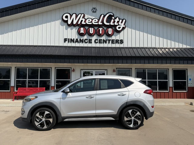 Silver SUV parked in front of Wheel City Auto Finance Centers storefront, sign visible above the building.