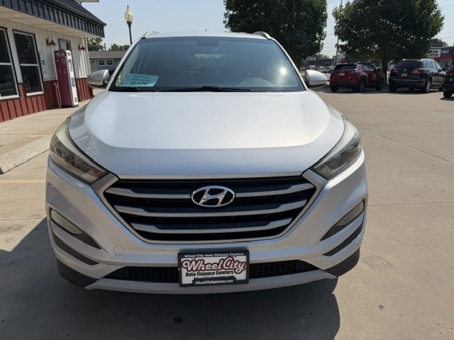 Front view of a white Hyundai SUV on a dealership lot, showing the Hyundai badge and Wheel City license plate frame.