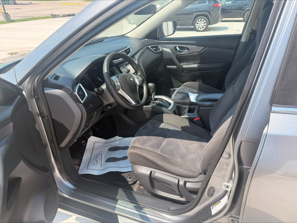 Interior of a car viewed from the driver's side, showing the steering wheel, dashboard, and front seats.