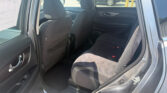 Interior of a car's back seat area with black cloth seats and rear door panel visible; parking lot seen through the open rear door window.