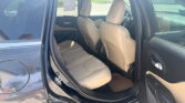 Open rear passenger door of a dark blue SUV, showing beige leather seats inside.