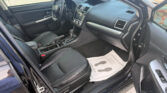 Interior of a dark SUV showing the driver’s seat, steering wheel, center console with a touchscreen, and the open front passenger area; door is open.