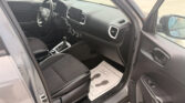 Interior of a car with the driver's seat, steering wheel, center touchscreen, gear shifter, and a floor mat that says 'Thank You'.