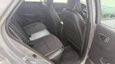 Interior of a car showing black leather seats with white stitching and the rear door open.