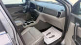 Interior view of a modern SUV cabin with front seats, steering wheel, center touchscreen, and gear shifter, driver-side door open