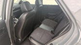 SUV back seat area with black fabric seats; front seats visible, rear door open to a parking lot outside.